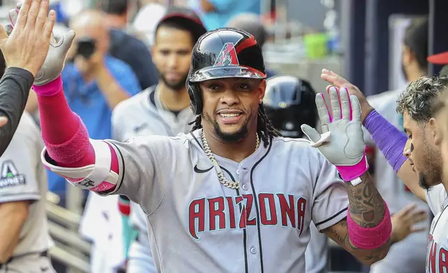 Arizona Diamondbacks' Ketel Marte high-fives teammates in the dugout after hitting a solo home run in the first inning of a baseball game against the Atlanta Braves, Tuesday, June 3, 2025, in Atlanta. (AP Photo/Colin Hubbard)