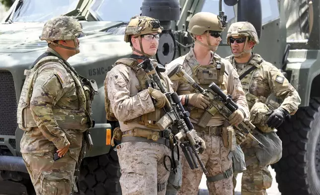 U.S Marines work next to members of the California National Guard outside of a federal building, Friday, June 13, 2025, in Los Angeles (AP Photo/Noah Berger)