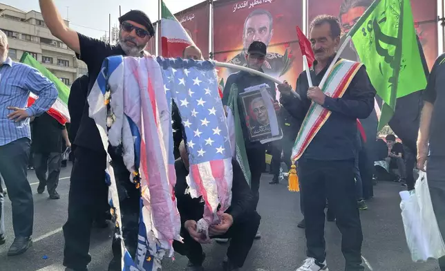 People burn a U.S. flag as they take part in a funeral ceremony of Iranian army generals, nuclear scientists and their family members who were killed in Israeli strikes, in Tehran, Iran, Saturday, June 28, 2025. (AP Photo/Vahid Salemi)