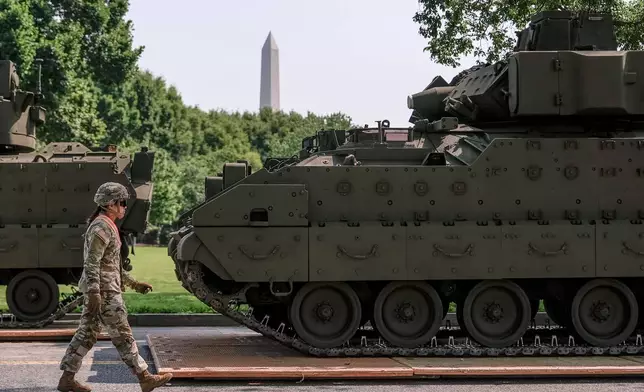 A U.S. Army soldier walks past a Bradley fighting vehicle staged in West Potomac Park ahead of an upcoming military parade commemorating the Army's 250th anniversary and coinciding with Donald Trump's 79th birthday, Wednesday, June 11, 2025, in Washington. (AP Photo/Julia Demaree Nikhinson)