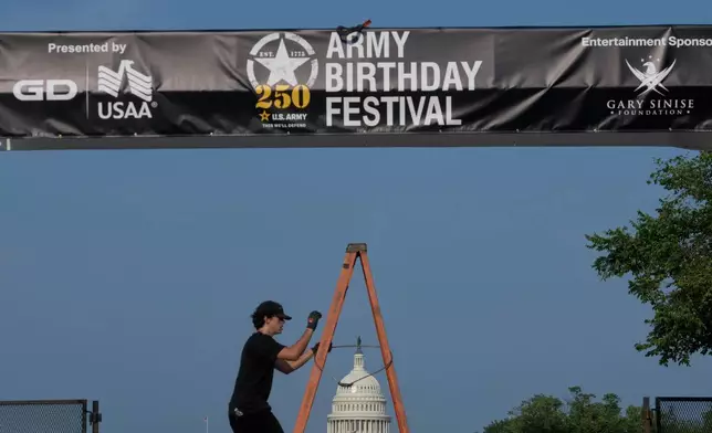 Crews work on setting up an archway on the National Mall, during preparations for an upcoming military parade commemorating the Army's 250th anniversary and coinciding with President Donald Trump's 79th birthday, Thursday, June 12, 2025, in Washington. (AP Photo/Rod Lamkey, Jr.)
