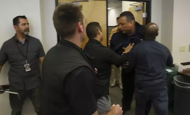 U.S. Sen. Alex Padilla, D-Calif., is pushed out of the room as Homeland Security Secretary Kristi Noem holds a news conference regarding the recent protests in Los Angeles on Thursday, June 12, 2025. (AP Photo/Etienne Laurent)