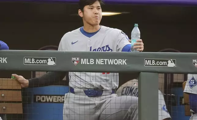 Los Angeles Dodgers designated hitter Shohei Ohtani looks on from the dugout in the fourth inning of a baseball game against the Colorado Rockies, Tuesday, June 24, 2025, in Denver. (AP Photo/David Zalubowski)