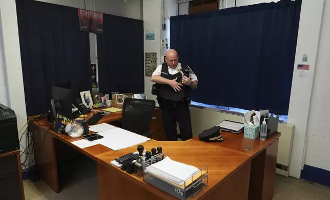 Philadelphia police captain Louis Higginson puts on his equipment, on April 28, 2025, in Philadelphia. (AP Photo/Matt Slocum)
