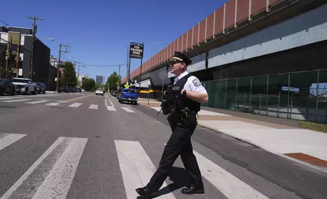 Philadelphia police captain Louis Higginson crosses a street after placing advisory flyers on automobiles, on April 28, 2025, in Philadelphia. (AP Photo/Matt Slocum)