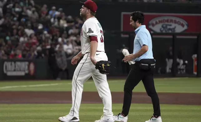 Arizona Diamondbacks pitcher Corbin Burnes, left, leaves a baseball game against the Washington Nationals in the fifth inning Sunday, June 1, 2025, in Phoenix. (AP Photo/Rick Scuteri)