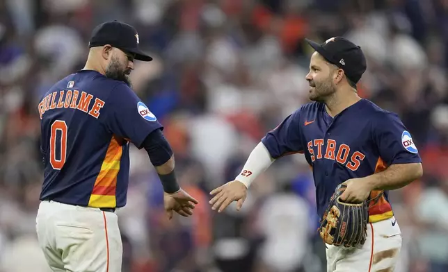 Houston Astros' Luis Guillorme (0) and Jose Altuve celebrate after a baseball game against the Chicago Cubs Sunday, June 29, 2025, in Houston. (AP Photo/David J. Phillip)