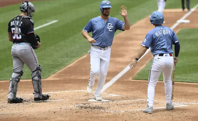 Washington Nationals' Nathaniel Lowe, center, scores on a bases loaded walk to Riley Adams during the second inning of a baseball game as Miami Marlins catcher Agustin Ramirez looks on at left, Saturday, June 14, 2025, in Washington. (AP Photo/Nick Wass)