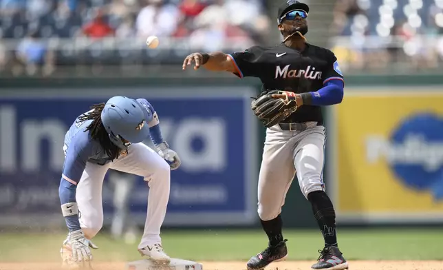 Washington Nationals' CJ Abrams, left, is forced out at second base as Miami Marlins shortstop Otto Lopez, right, throws to first but can't get Nationals' James Wood during the eighth inning of a baseball game, Saturday, June 14, 2025, in Washington. (AP Photo/Nick Wass)