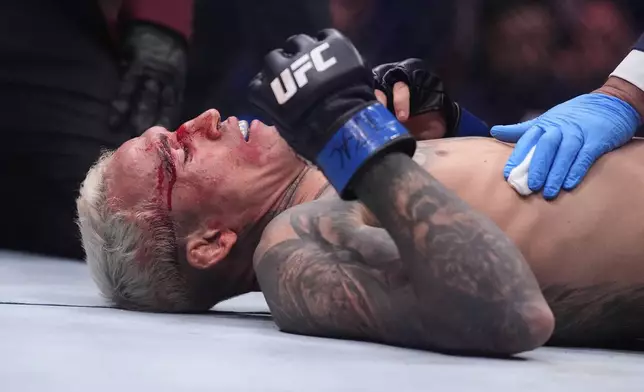 Charles Oliveira lies on the mat after losing to Ilia Topuria in a lightweight title fight at UFC 317, Saturday, June 28, 2025, in Las Vegas. (AP Photo/John Locher)