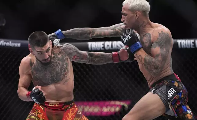 Ilia Topuria, left, fights Charles Oliveira in a lightweight title fight at UFC 317, Saturday, June 28, 2025, in Las Vegas. (AP Photo/John Locher)