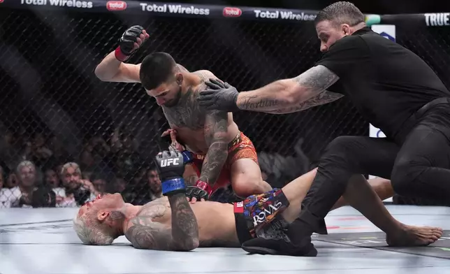 Ilia Topuria pounds on Charles Oliveira in a lightweight title fight at UFC 317, Saturday, June 28, 2025, in Las Vegas. (AP Photo/John Locher)