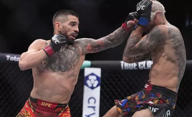 Ilia Topuria, left, fights Charles Oliveira in a lightweight title fight at UFC 317, Saturday, June 28, 2025, in Las Vegas. (AP Photo/John Locher)
