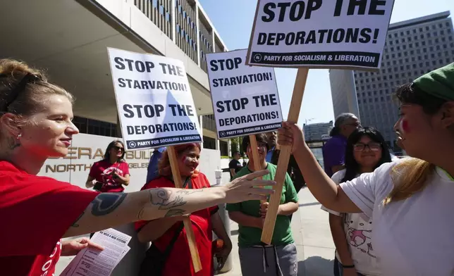 Community organizers gather outside the Federal Building after federal immigration authorities conducted an operation Friday, June 6, 2025, in Los Angeles. (AP Photo/Damian Dovarganes)
