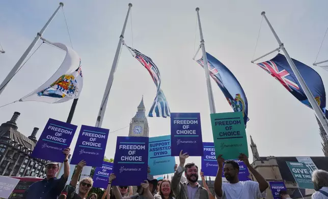 Demonstrators for assisted dying hold banners outside Parliament in London, Friday, June 20, 2025, as British lawmakers are set to vote Friday on whether to back a bill to help terminally ill adults end their lives in England and Wales. (AP Photo/Kirsty Wigglesworth)