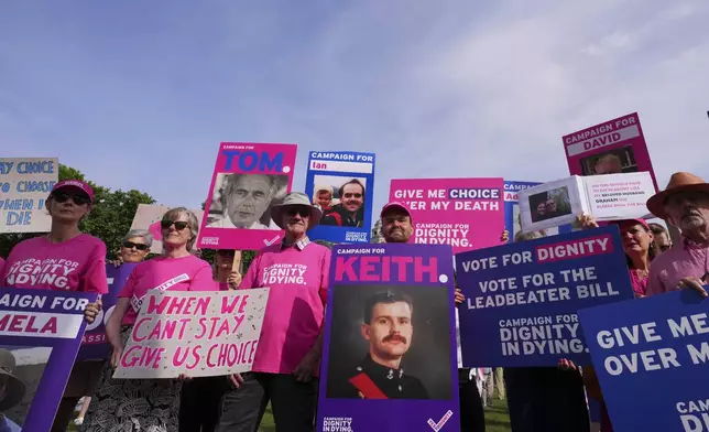 Demonstrators for assisted dying hold banners outside the Parliament in London, Friday, June 20, 2025, as British lawmakers are set to vote Friday on whether to back a bill to help terminally ill adults end their lives in England and Wales. (AP Photo/Kirsty Wigglesworth)