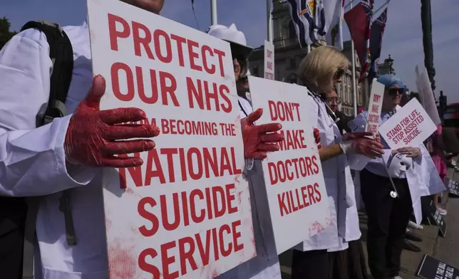 Demonstrators against assisted dying hold banners outside Parliament in London, Friday, June 20, 2025, as British lawmakers are set to vote Friday on whether to back a bill to help terminally ill adults end their lives in England and Wales. (AP Photo/Kirsty Wigglesworth)