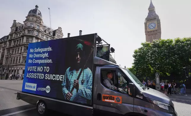 A van displaying a sign passes Big Ben as demonstrators both for and against assisted dying hold banners outside Parliament in London, Friday, June 20, 2025, as British lawmakers are set to vote Friday on whether to back a bill to help terminally ill adults end their lives in England and Wales. (AP Photo/Kirsty Wigglesworth)