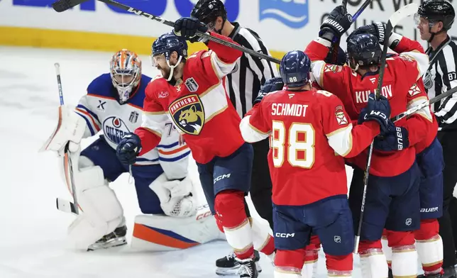 Florida Panthers' Sam Reinhart, second left, celebrates his goal against Edmonton Oilers goalie Stuart Skinner (74) with teammates during the second period in Game 6 of the NHL hockey Stanley Cup Final in Sunrise, Fla., Tuesday, June 17, 2025. (Nathan Denette/The Canadian Press via AP)