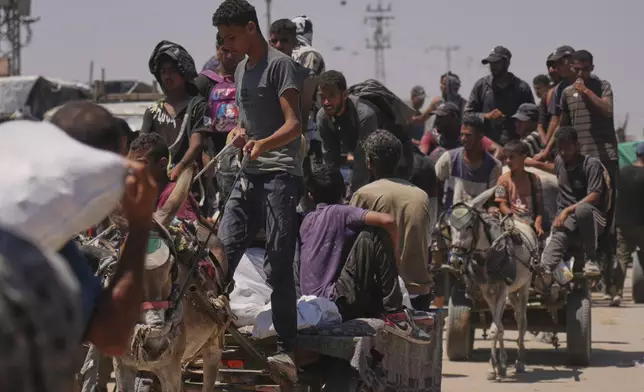 Palestinians carry bags containing food and humanitarian aid packages delivered by the Gaza Humanitarian Foundation, a U.S.-backed organization, in Rafah, southern Gaza Strip, Wednesday, June 25, 2025. (AP Photo/Abdel Kareem Hana)