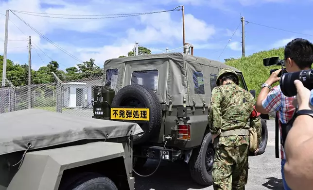 A Japan Self-Defence Forces vehicle enters an area of ammunition store in the town of Yomitanson, Okinawa prefecture, southern Japan Monday, June 9, 2025. A yellow sign reads "Bomb Disposal." (Kyodo News via AP)