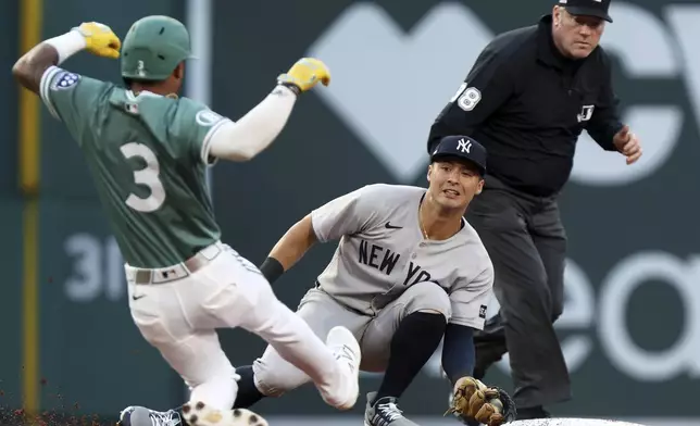 The Boston Red Sox's Ceddanne Rafaela (3) is tagged out by New York Yankees shortstop Anthony Volpe, center, as he is caught stealing second base during a baseball game Friday, June 13, 2025, in Boston. (AP Photo/Jim Davis)