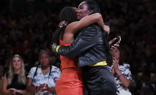 Former Los Angeles Sparks player Candace Parker, left, and former teammate Lisa Leslie, right, embrace during Parker's jersey retirement ceremony during a WNBA basketball game between the Sparks and the Chicago Sky, Sunday, June 29, 2025, in Los Angeles. (AP Photo/Jessie Alcheh)