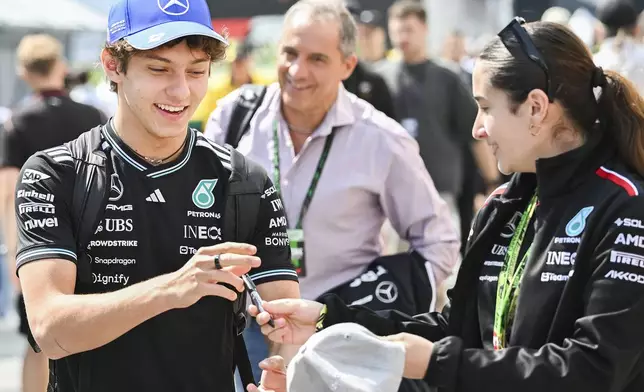 Mercedes driver Kimi Antonelli, of Italy, signs autographs as he walks through the paddocks ahead of the third practice session at the F1 Canadian Grand Prix auto race, in Montreal, Saturday, June 14, 2025. (Graham Hughes /The Canadian Press via AP)