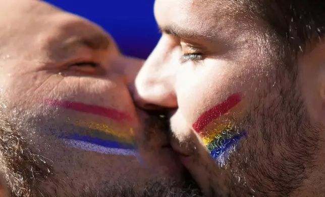 Two men kiss on the street during the Lisboa Pride march down Liberdade Avenue in Lisbon, Saturday, June 7, 2025. (AP Photo/Armando Franca)