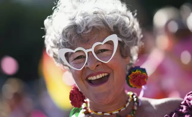 A reveler dances on the street during the Lisboa Pride march down Liberdade Avenue in Lisbon, Saturday, June 7, 2025. (AP Photo/Armando Franca)