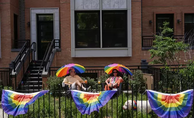 People preparing to watch the World Pride parade sit in their front yard, Saturday, June 7, 2025, in Washington. (AP Photo/Julia Demaree Nikhinson)