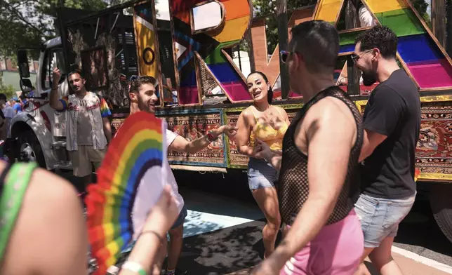 Attendees of Iranian descent Niloofar Jebelli, of Falls Church, Va., from second left, Leila Beig, of Washington, Arash Azma, of Washington, and Adoril Oshana, of San Jose, Calif., dance alongside the Iran pride float during the World Pride parade, Saturday, June 7, 2025, in Washington. (AP Photo/Jacquelyn Martin)