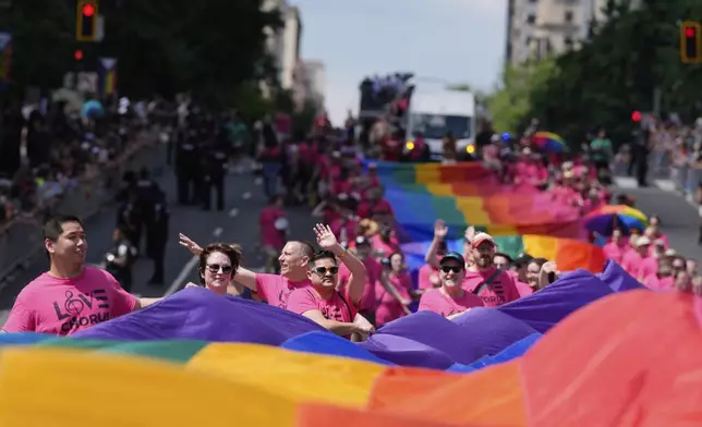 Participants carry a large rainbow flag during the World Pride parade, Saturday, June 7, 2025, in Washington. (AP Photo/Mark Schiefelbein)