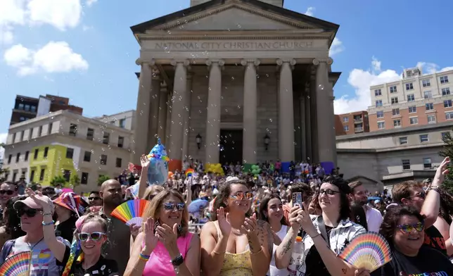 People watch the World Pride parade, Saturday, June 7, 2025, in Washington. (AP Photo/Julia Demaree Nikhinson)