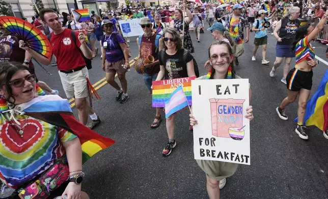 People carrying signs march during the World Pride parade, Saturday, June 7, 2025, in Washington. (AP Photo/Alex Brandon)