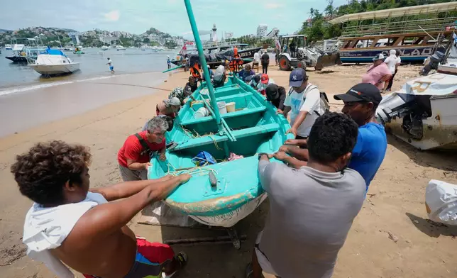Boats are removed from the water to Manzanillo beach ahead of the arrival of Hurricane Erick in Acapulco, Mexico, Wednesday, June 18, 2025. (AP Photo/Fernando Llano)