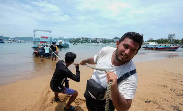 Boats are removed from the water to Manzanillo beach ahead of the arrival of Hurricane Erick in Acapulco, Mexico, Wednesday, June 18, 2025. (AP Photo/Fernando Llano)