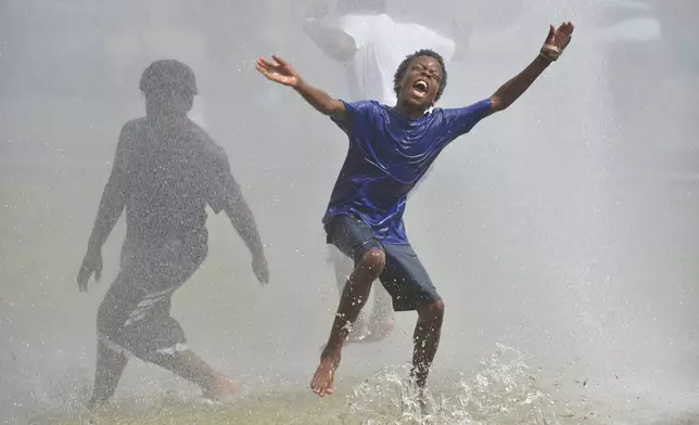 Children cool off during the Benton Harbor Department of Public Safety's Spray &amp; Play held at the Pete Mitchell City Center Park in downtown Benton Harbor, Mich., on Tuesday, June 24, 2025. (Don Campbell/The Herald-Palladium via AP)