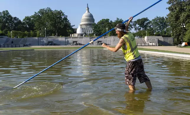 Working before the temperature hits 100 degrees today, Jeffrey Adcock cleans the reflecting pool in Lower Senate Park at the Capitol in Washington, Tuesday, June 24, 2025. (AP Photo/J. Scott Applewhite)