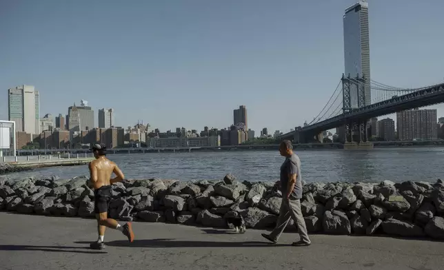 People exercise on the Brooklyn waterfront during a heatwave on Tuesday, June 24, 2025, in New York. (AP Photo/Olga Fedorova)