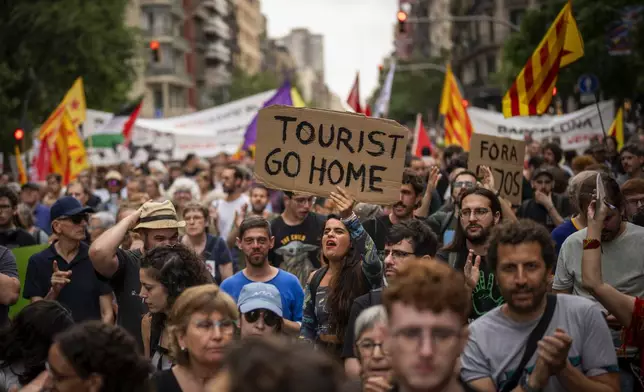 FILE - Demonstrators march shouting slogans against the Formula 1 Barcelona Fan Festival in downtown Barcelona, Spain, Wednesday, June 19, 2024, during residents protest against mass tourism. (AP Photo/Emilio Morenatti, File)