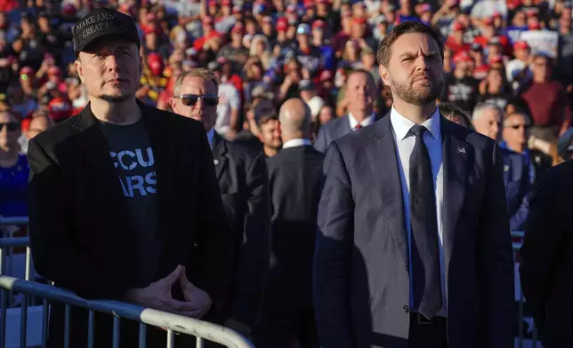 FILE - Elon Musk, left, and Republican vice presidential nominee Sen. JD Vance, R-Ohio, listen as Republican presidential nominee former President Donald Trump speaks at a campaign rally, Oct. 5, 2024, in Butler, Pa. (AP Photo/Evan Vucci, File)