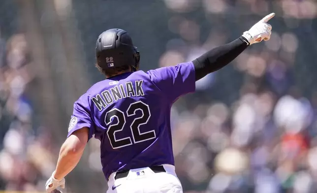 Colorado Rockies' Mickey Moniak gestures as he circles the bases after hitting a three-run home run off Arizona Diamondbacks starting pitcher Brandon Pfaadt in the fifth inning of a baseball game Sunday, June 22, 2025, in Denver. (AP Photo/David Zalubowski)