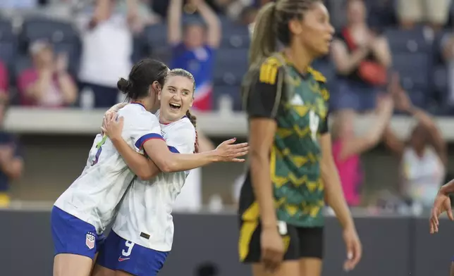 United States' Ally Sentnor is congratulated by teammate Emily Fox, left, after scoring as Jamaica's Chantelle Swaby, right, walks past during the first half of an international friendly soccer match Tuesday, June 3, 2025, in St. Louis. (AP Photo/Jeff Roberson)