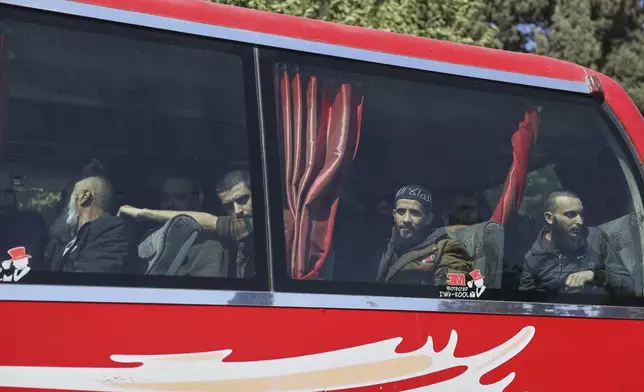 Freed prisoners sit inside a bus following their release during a prisoner exchange between Syrian authorities and the Kurdish-led Syrian Democratic Forces in the Sheikh Maqsoud neighborhood of Aleppo, Syria, Monday, June 2, 2025. (AP Photo/Omar Albam)