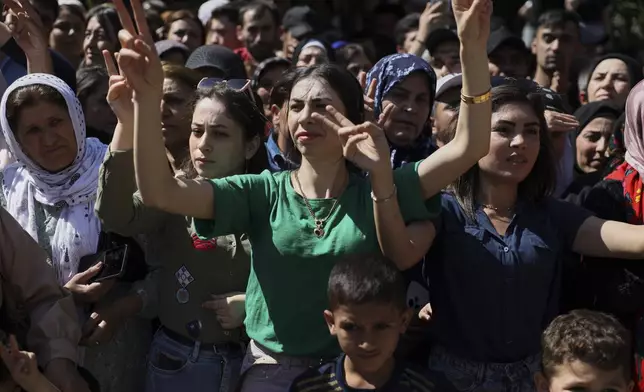 Kurdish women flash victory signs as they celebrate the release of prisoners during an exchange between Syrian authorities and the Kurdish-led Syrian Democratic Forces in the Sheikh Maqsoud neighborhood of Aleppo, Syria, Monday, June 2, 2025. (AP Photo/Omar Albam)
