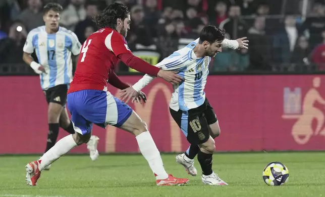 Argentina's Lionel Messi, right, and Chile's Francisco Sierralta battle for the ball during a qualifying soccer match for the FIFA World Cup 2026 in Santiago, Chile, Thursday, June 5, 2025. (AP Photo/Luis Hidalgo)