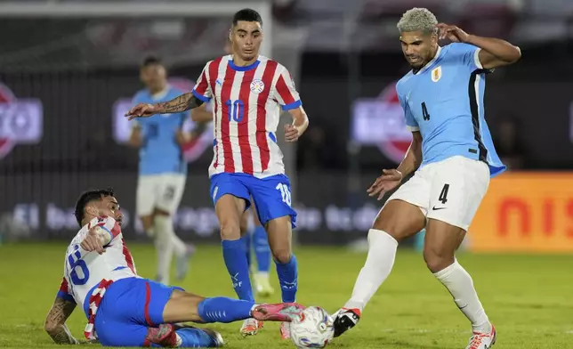 Uruguay's Ronald Araujo, right, and Paraguay's Diego Gomez battle for the ball during a qualifying soccer match for the FIFA World Cup 2026 in Asuncion, Paraguay, Thursday, June 5, 2025. (AP Photo/Jorge Saenz)
