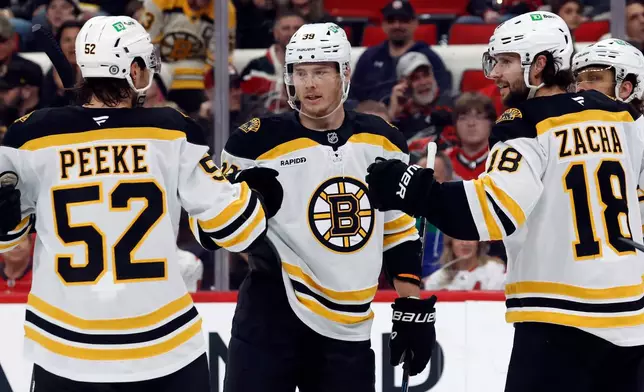FILE - Boston Bruins' Morgan Geekie, center, celebrates after his goal with teammates during the first period of an NHL hockey game against the Carolina Hurricanes in Raleigh, N.C., March 6, 2025. (AP Photo/Karl DeBlaker, File)