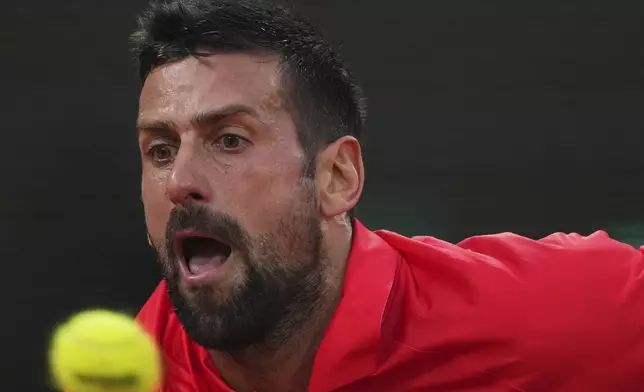 Serbia's Novak Djokovic reaches for the ball against Austria's Filip Misolic during their third-round match of the French Tennis Open at the Roland-Garros stadium in Paris, Saturday, May 31, 2025. (AP Photo/Lindsey Wasson)